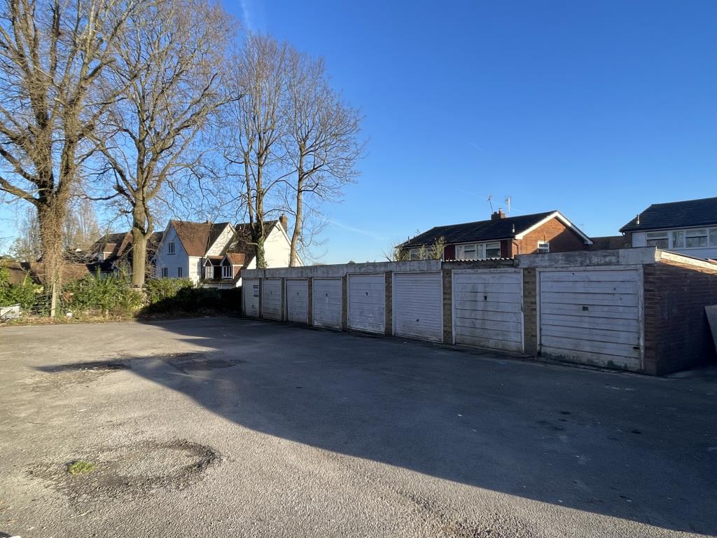 Lot: 10 - LAND AND SIXTEEN GARAGES WITH POTENTIAL FOR DEVELOPMENT - View of eastern block of eight garages and forecourt